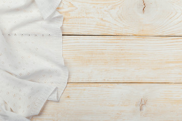 Top view on a white wooden table with a linen kitchen towel or textile napkin. a tablecloth on a light wood countertop.
