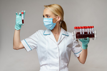 medical doctor nurse woman wearing protective mask and gloves - holding rack with virus blood tests