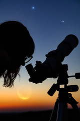 Fototapeta premium Silhouette of a woman and telescope with twilight sky.