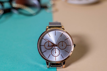 Silver watch isolated on a green and cream background.
