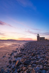 Fototapeta na wymiar Lighthouse on beautiful beach, sunset background and blue sky, copy space
