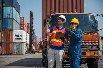 Foreman and dock worker staff working checking at Container cargo harbor holding clipboard....