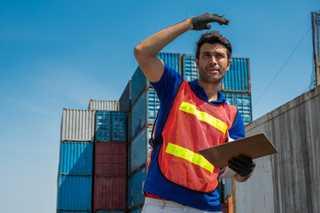 Foreman holding clipboard working at Container cargo harbor. Business Logistics import export shipping concept.