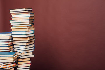 a lot of stacks of educational books in the college library on a brown background