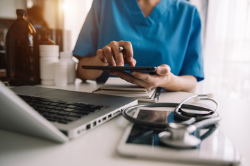 Medical technology concept. Doctor working with mobile phone and stethoscope in modern office
