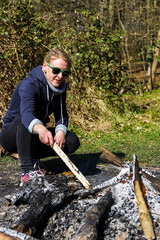outdoor woman takes care of campfire