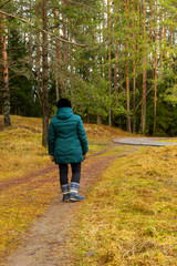 A woman walks along a forest path.