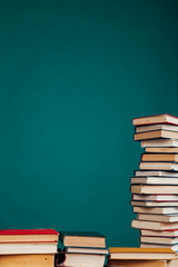 many stacks of educational books in the university library on a green background