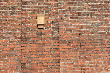 Bat box on an old red  brick wall specifically designed to provide shelter for roosting bats