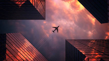The plane flies over the skyscrapers. Wonderful composition with sunset