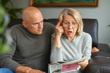 Grandson with his grandmother reading newspaper.News, press, media, holidays and people concept .