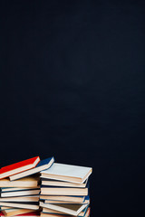 many stacks of educational books in the university library on a black background