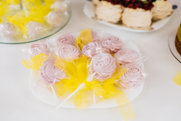 Fototapeta na wymiar sweet pink lollypops on a white plate