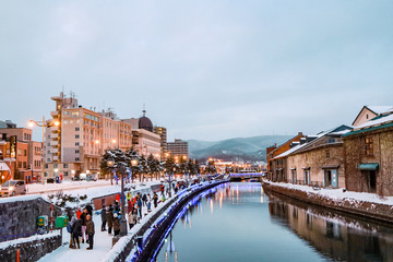 Otaru Canal in Winter with twilight light. One of Beautiful scene in Otaru canal with old warehouses. It is a popular tourist attraction of Hokkaido, Japan. © chayakorn