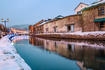 Obraz premium Otaru Canal in Winter with twilight light. One of Beautiful scene in Otaru canal with old warehouses. It is a popular tourist attraction of Hokkaido, Japan.