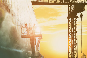 Washing, Cleaning cargo ship on high in floating dry dock with water high pressure jet cleans of...