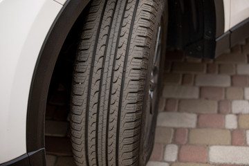 Car rim detail. Car wheel. selective focus. wheel of a white car while parked on the sidewalk