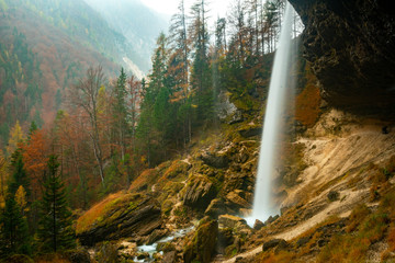waterfall on the mountain and trees on a rainy autumn day