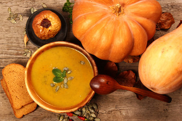 Bowl of pumpkin soup with wooden spoon