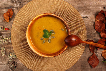 Bowl of pumpkin soup with wooden spoon