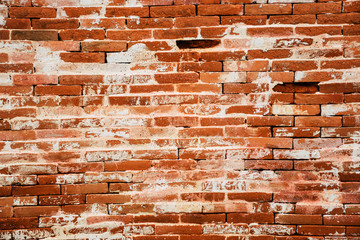 Background of red brick wall with peeling plaster. Red old brick texture, surface.
