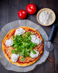 Pizza with tomatoes,corn lettuce  and strachatella cheese, top view