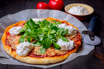 Pizza with tomatoes,corn lettuce  and strachatella cheese