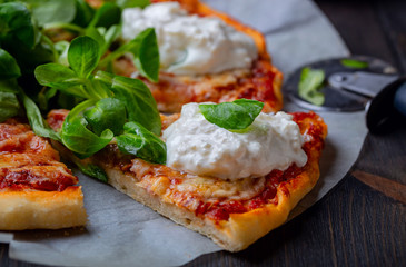 Pizza with tomatoes,corn lettuce  and strachatella cheese, close up
