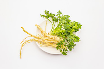 Parsley greens and roots isolated on white background