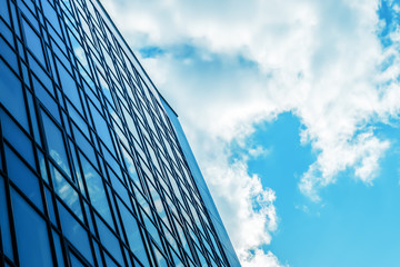 Modern office business building on a background of blue sky with clouds
