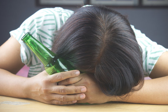 Bottle of Beer and background images in women headaches. The result of excessive alcohol consumption.