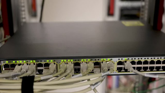 Netzwerk Switch verbunden mit Netzwerkkabel RJ45 Patchkabel und Glasfaserkabel in einem Rechenzentrum