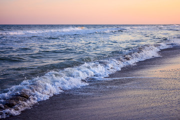Сoast of the sea and waves at twilight sunset