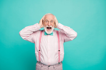 Photo of amazed grandpa positive facial expression arms on head good mood sale shopping advert wear specs pink shirt suspenders bow tie pants isolated bright teal color background