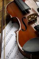 Naklejka premium Beautiful violin, bow and note sheets on wooden table