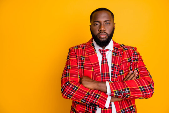 Photo of attractive dark skin guy look seriously arms crossed not smiling strict boss person wear plaid red costume blazer white shirt isolated bright yellow color background