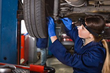 Female master is repairing car on her workplace