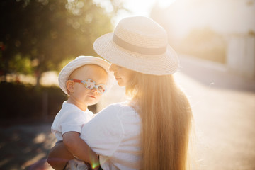 Happy Girl in a hat at sunset, a child with glasses, an occluder, a child with strabismus