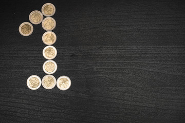2 euro coins on dark wooden table