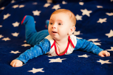 Fototapeta premium little boy lies on a blue background with stars