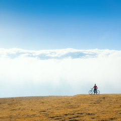 Obraz premium biker with bicycle watching foggy mountain on nature