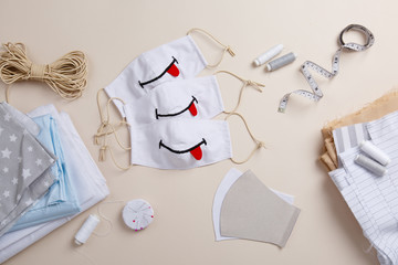 Funny handmade child anti-virus mask. Homemade mask with smile. DIY face mask for stay safe at pandemic or quarantine. Sewing zero waste Cotton natural kids mask against infection. Smile and stay safe