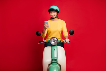 Portrait of her she nice attractive lovely cheerful cheery girl sitting on moped using cell 5g app...
