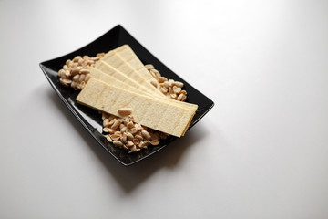 long potato chips, roasted peeled peanuts, salted beer snacks in black plate