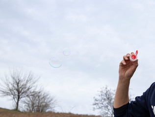 Soap bubbles in the hands. Sunny day spring. Outdoor.