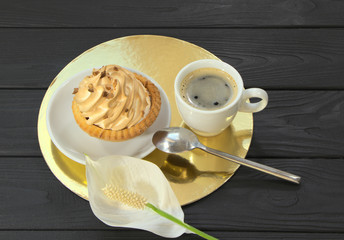 Cake tartlet with protein cream coffee in a white cup. Confectionery for breakfast in a cafe. White dishes for a coffee drink, a teaspoon.