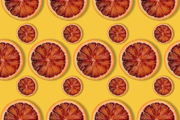 citrus background, pattern of red orange slices on yellow background
