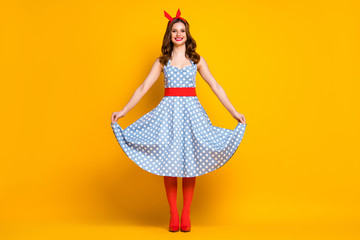 Full size photo of cheerful lovely girl enjoy spring free time holiday weekend touch her polka-dot outfit shine stockings isolated over vivid color background