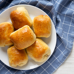 Home-baked Beef Russian Bierocks on a white plate on a white wooden background, top view. Flat lay, overhead, from above. Copy space.