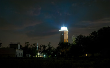 Shining lighthouse against a starry night sky